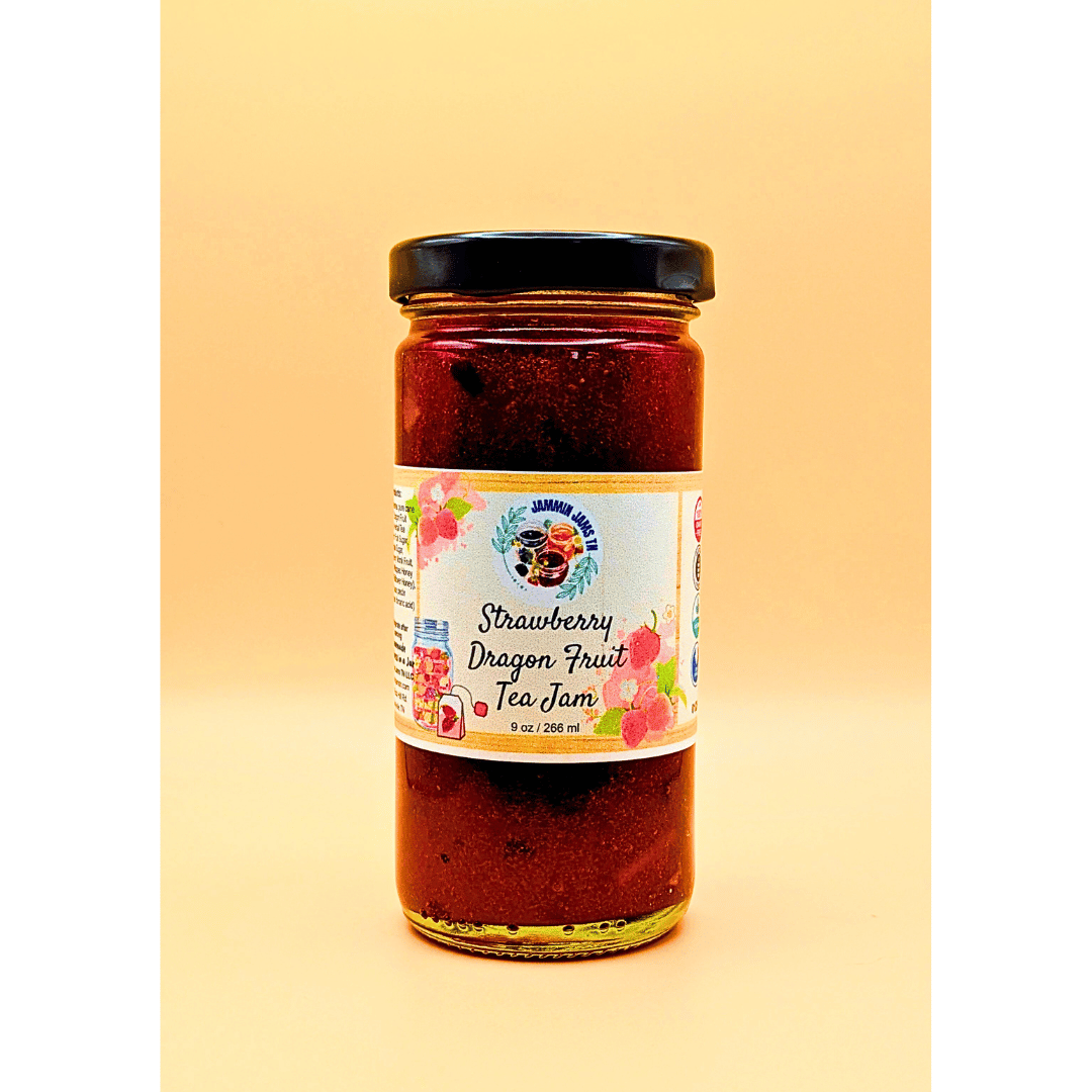 Jar of strawberry dragon fruit tea jam with a colorful label on a yellow background